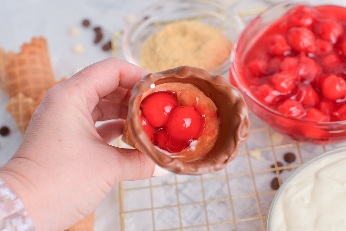 hand holding cone filled with cherry filling