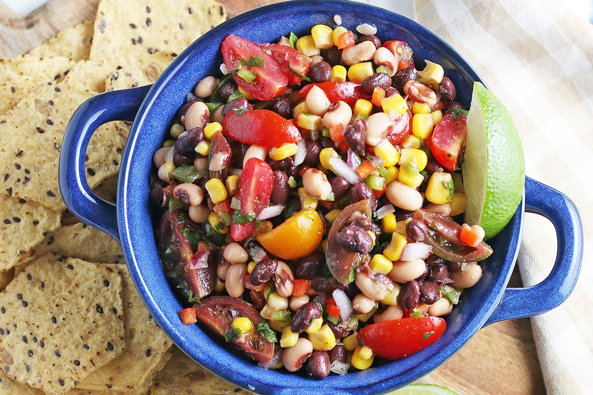 overhead of cowboy caviar with tortilla chips and lime