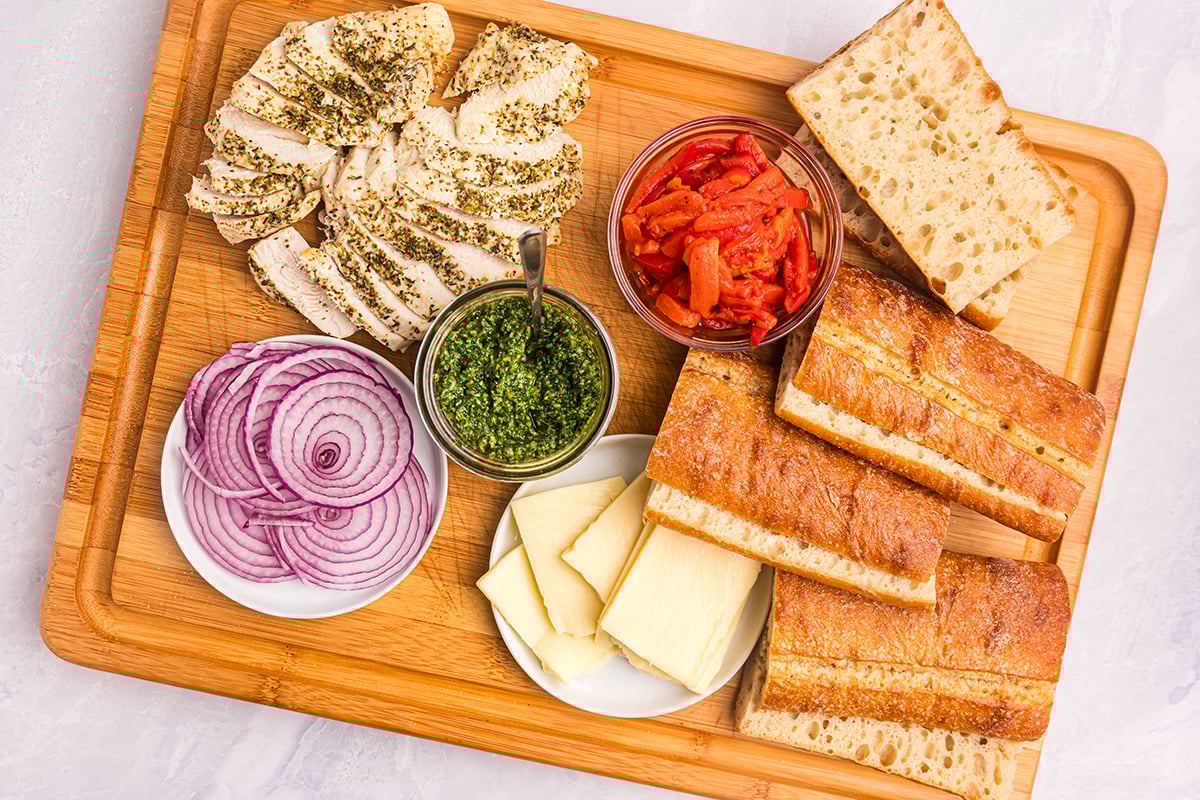 overhead shot of italian chicken panini ingredients on cutting board