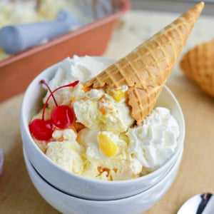 two bowls with mango ice cream recipe, cherries and a waffle cone