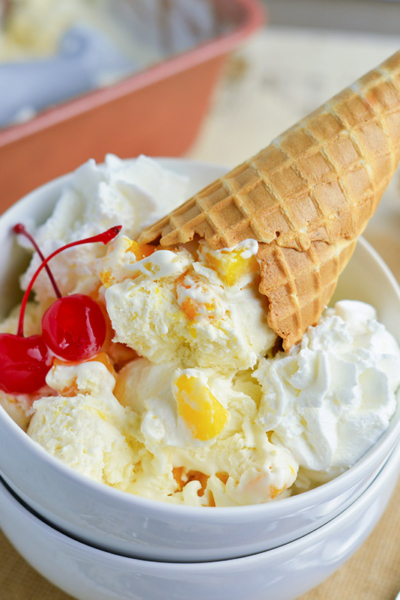 two bowls with mango ice cream recipe, cherries and a waffle cone