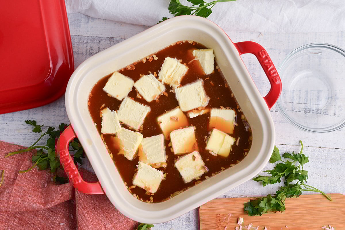 overhead shot of butter, broth and rice in baking dish