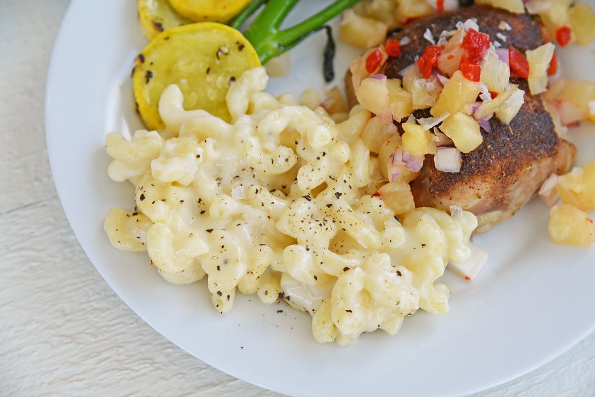 truffled mac and cheese with chicken thighs on a white plate