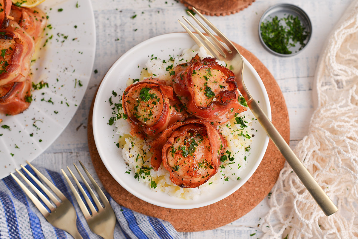 overhead shot of three bacon wrapped scallops on a plate