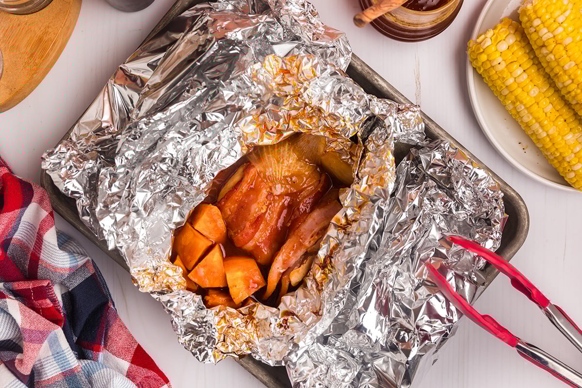 overhead shot of chicken foil packet opening on sheet pan