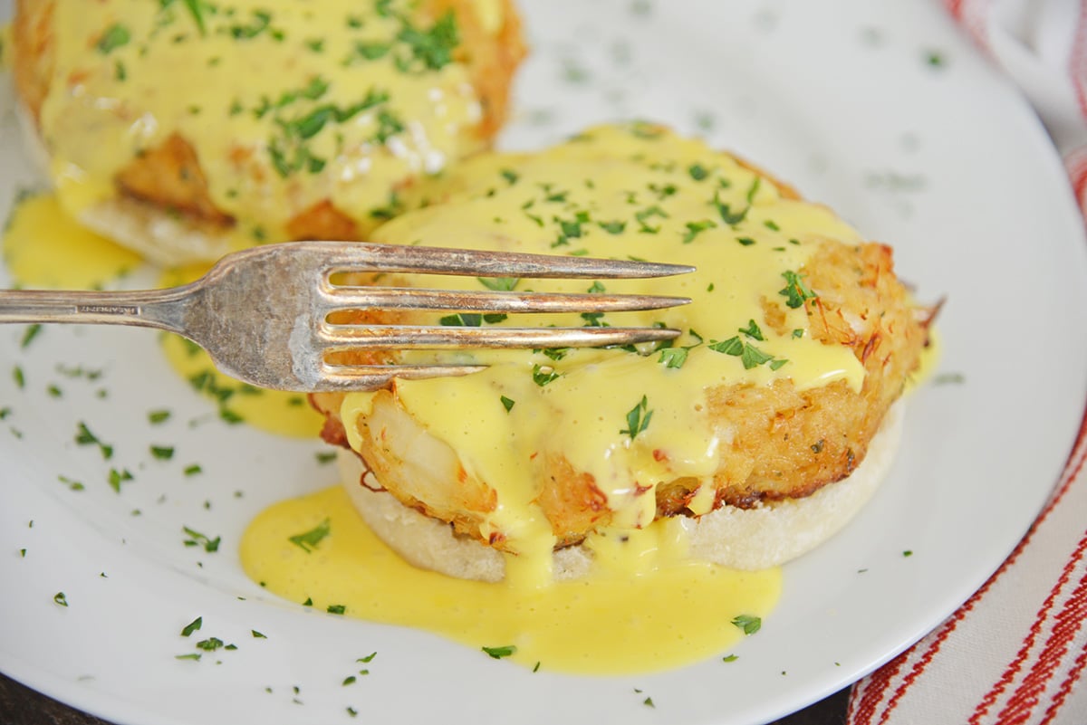 fork digging into crab cake hollandaise