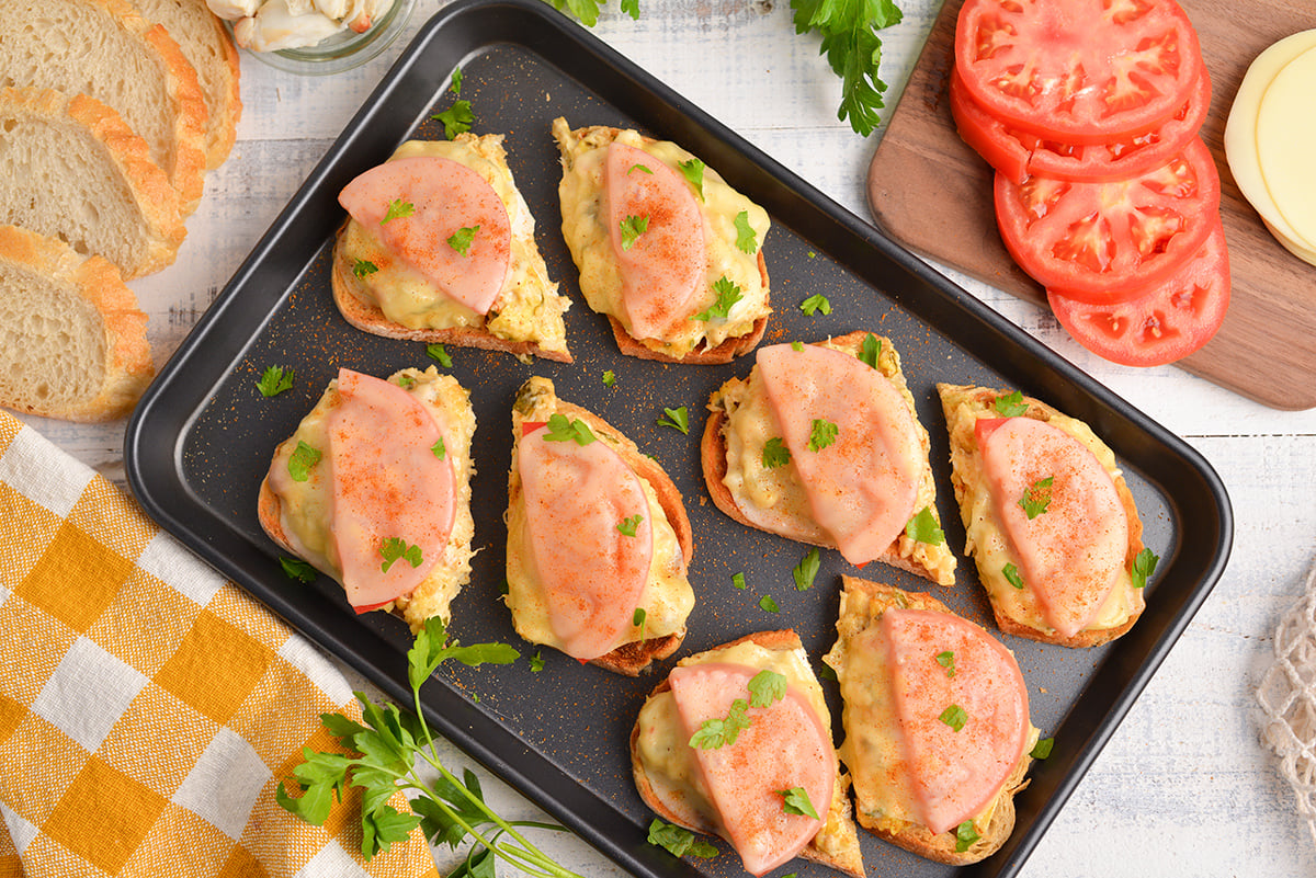 crab melt sandwich halves on baking sheet