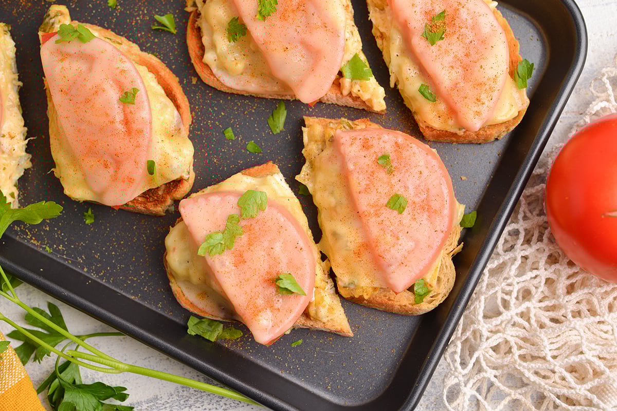 close up overhead shot of open faced crab melt sandwich on baking sheet