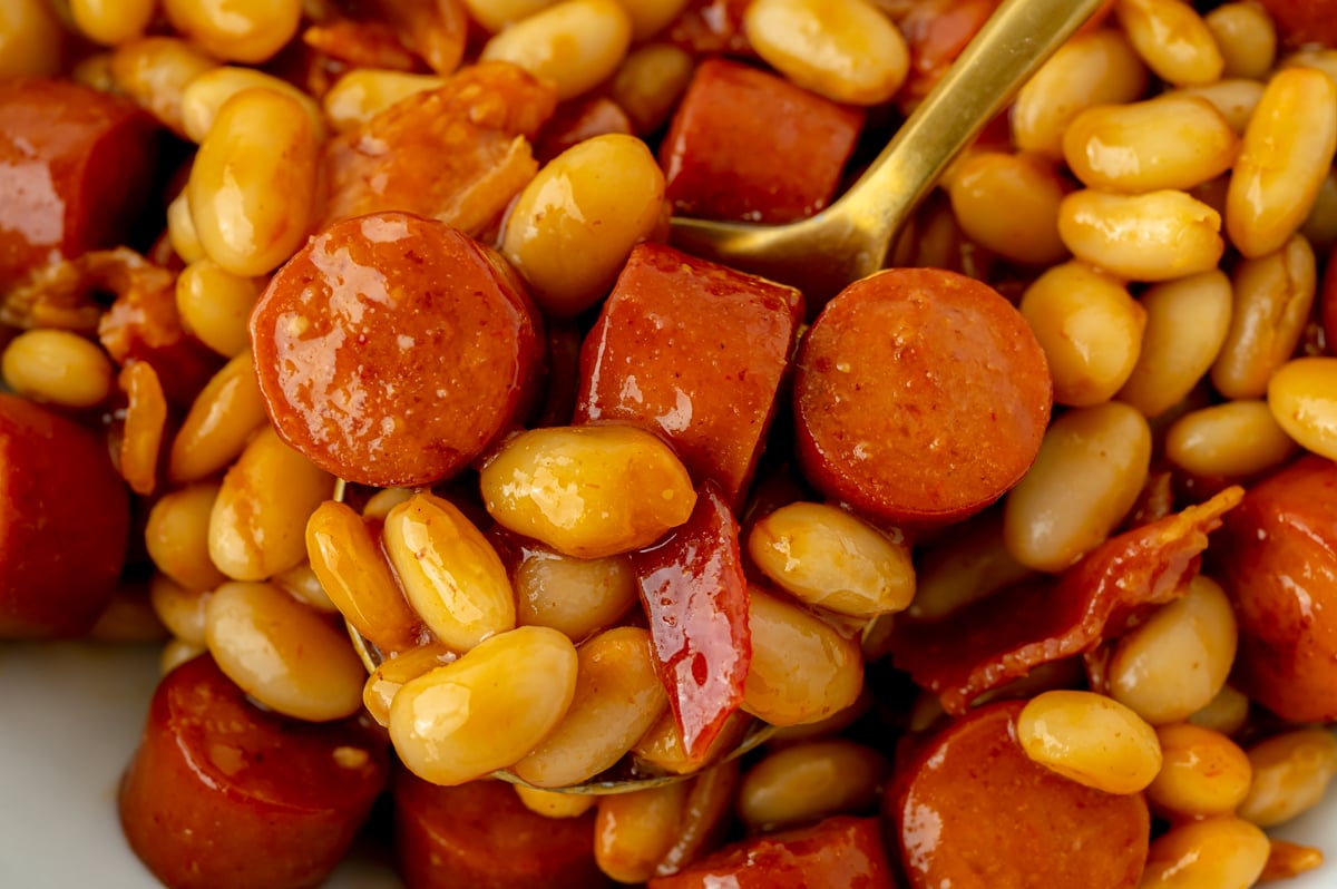 close up shot of bite of beanie weenies on spoon