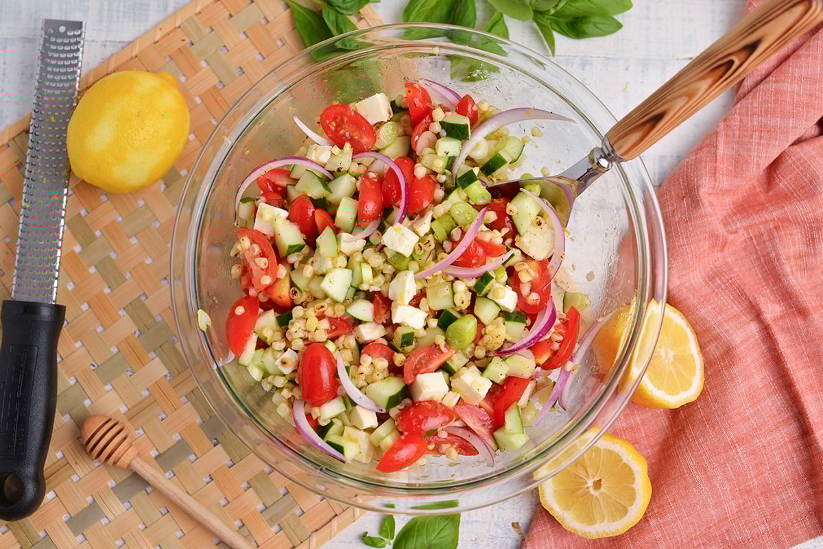 corn tomato salad in bowl with spoon