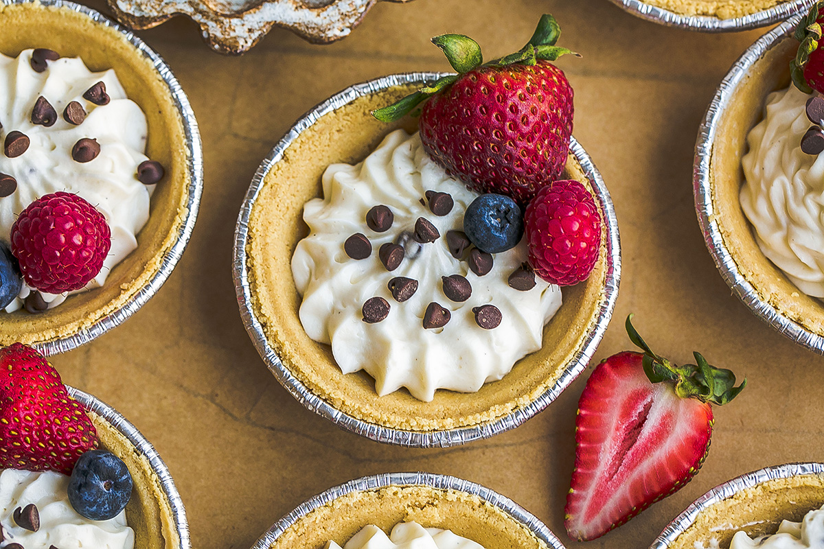close up overhead shot of mini cheesecake topped with chocolate chips and fruit
