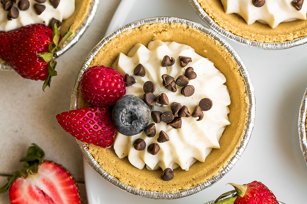 overhead shot of mini cheesecake topped with chocolate chips and berries