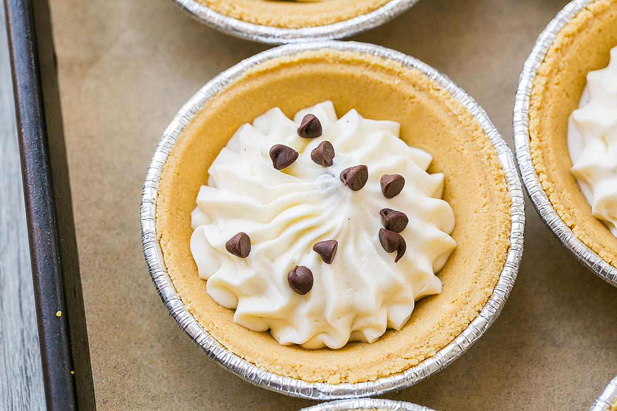 close up angled shot of mini chocolate chip cheesecakes