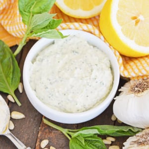 angled shot of pesto aioli sauce in white bowl