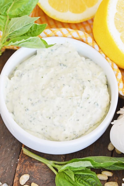 angled shot of pesto aioli sauce in white bowl