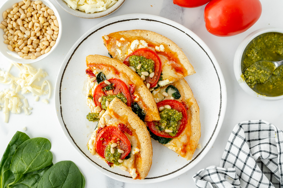 overhead shot of pesto pizza slices on plate