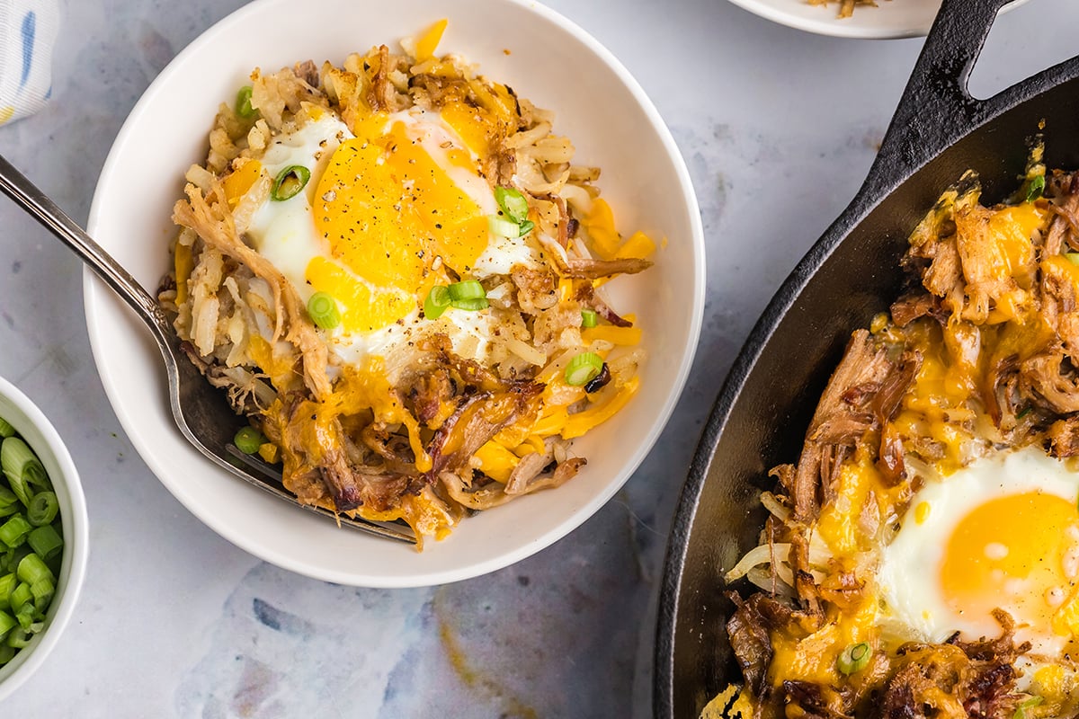 overhead shot of skillet and bowl of pork hash a