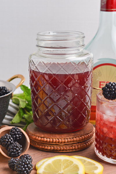 straight on shot of jar of blackberry brandy with blackberry bourbon smash