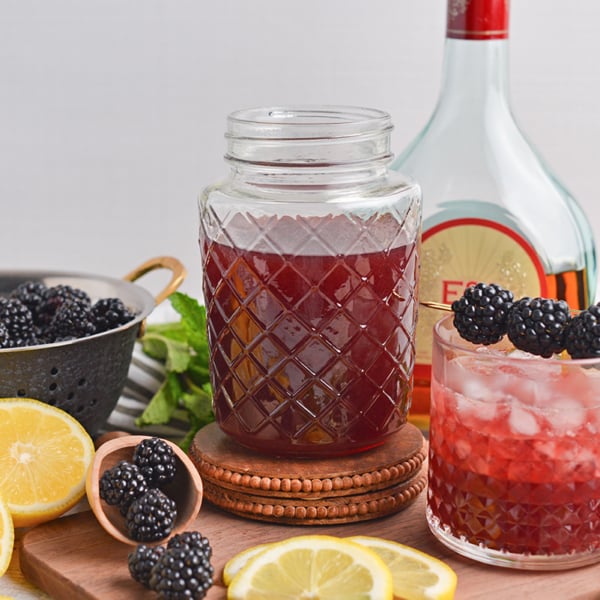 straight on shot of jar of blackberry brandy with blackberry bourbon smash