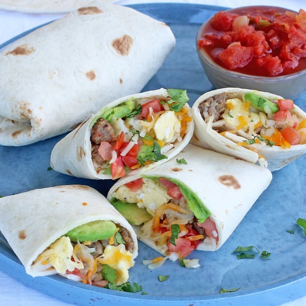 Plated breakfast burritos with salsa on a blue plate
