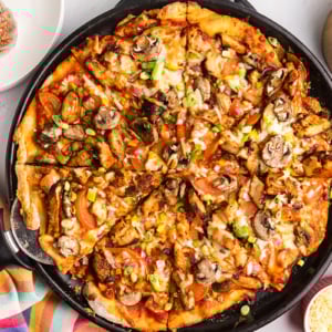 overhead shot of sliced jerk chicken pizza
