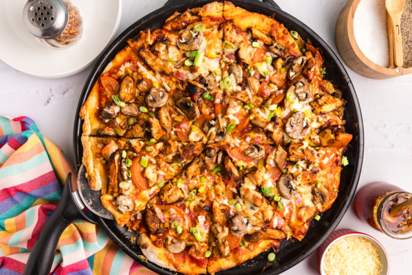 overhead shot of sliced jerk chicken pizza