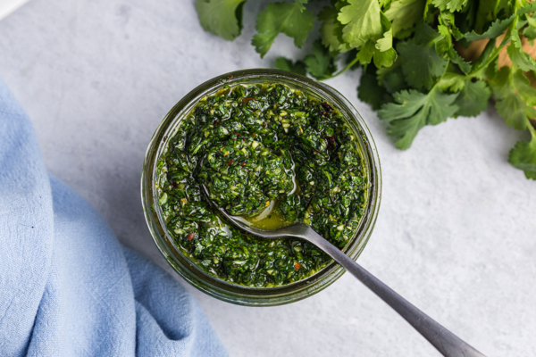 overhead of small spoon in homemade chimichurri sauce