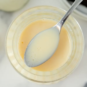 overhead shot of spoon of sweetened condensed milk