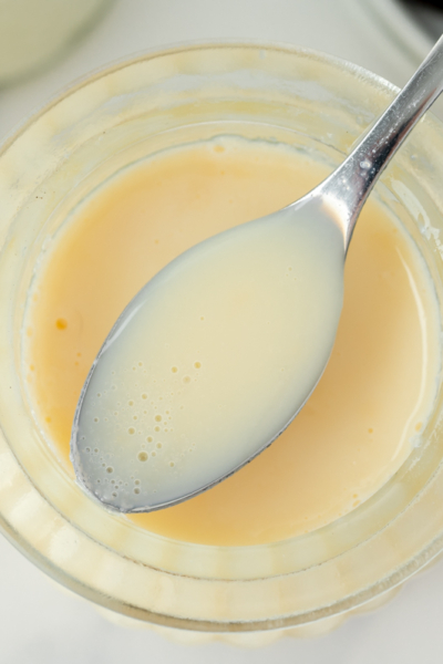 overhead shot of spoon of sweetened condensed milk