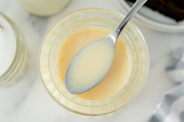 overhead shot of spoon of sweetened condensed milk