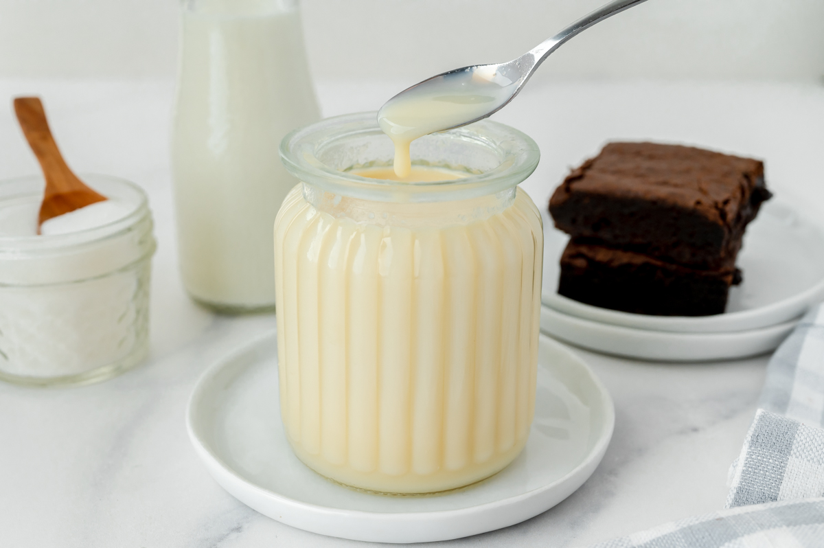 spoon in jar of sweetened condensed milk