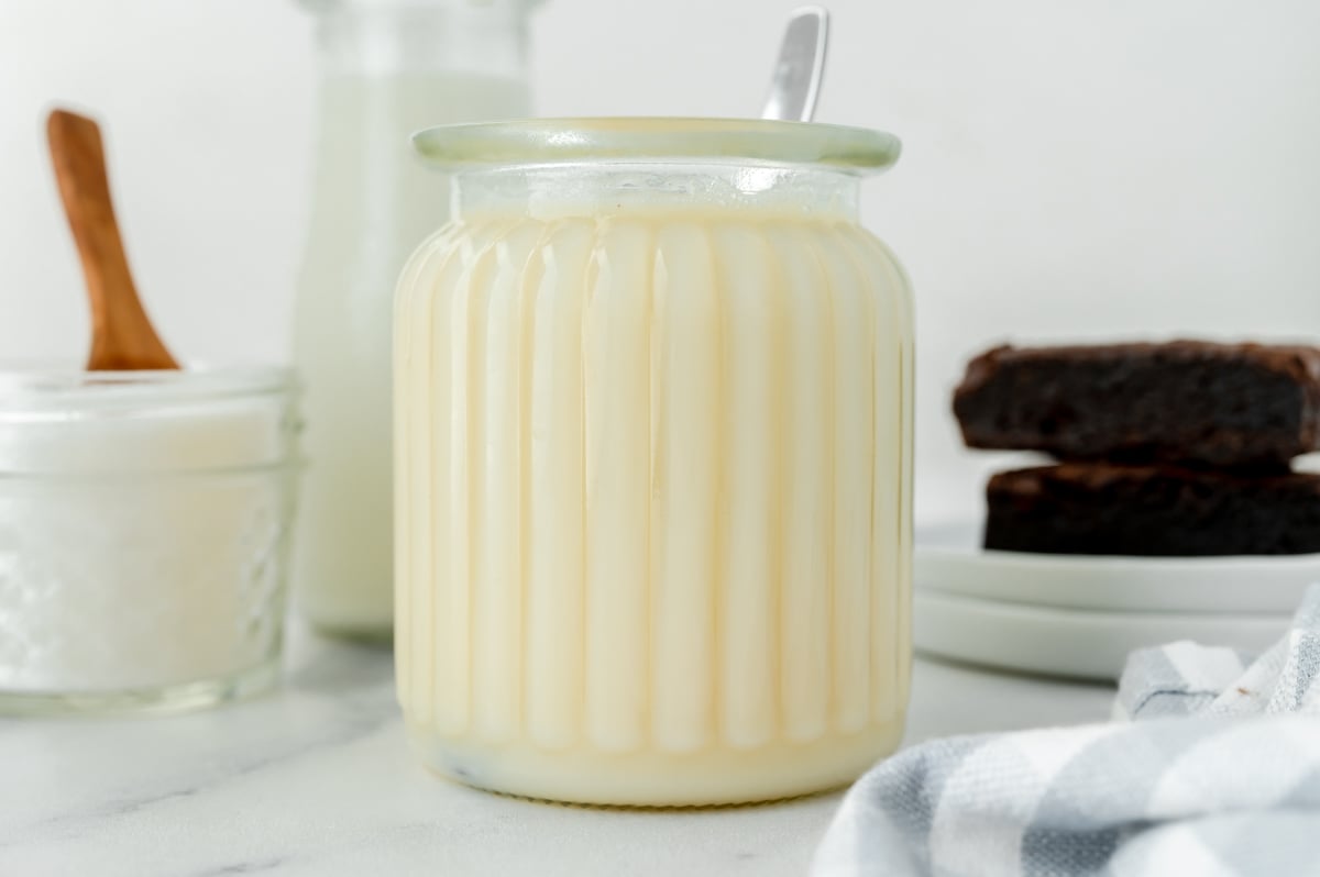 straight on shot of spoon in jar of sweetened condensed milk