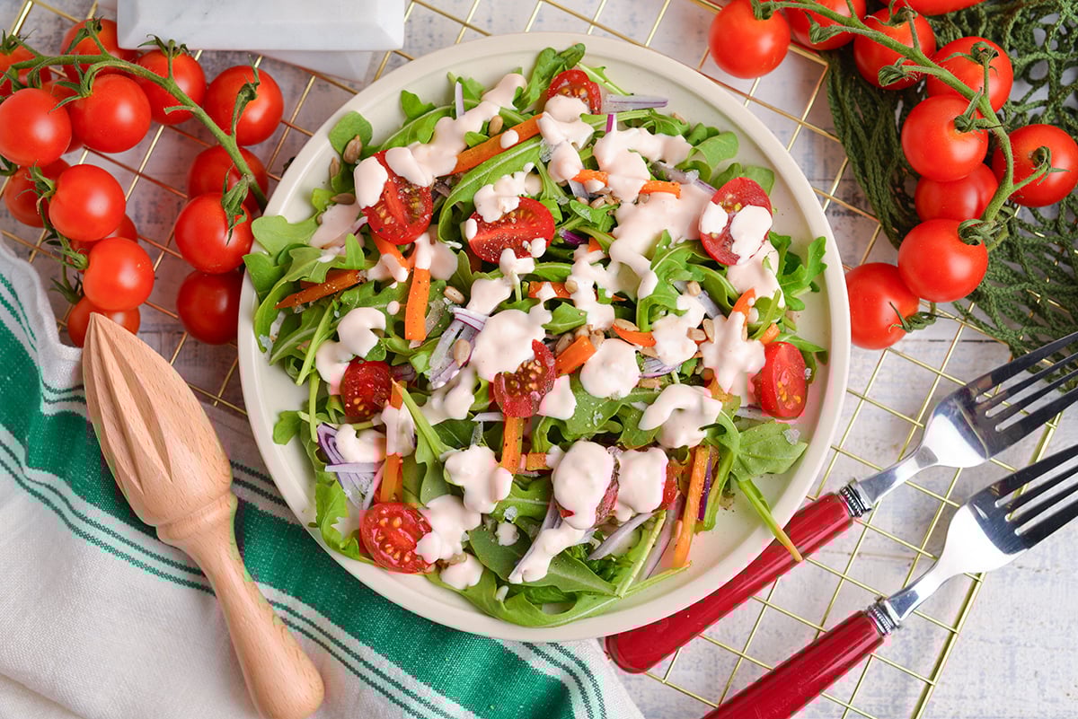 overhead shot of salad drizzled with creamy dressing