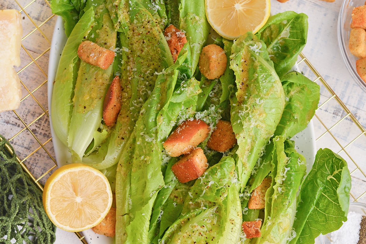 close up of romaine lettuce with garlic salad dressing, and fresh lemons