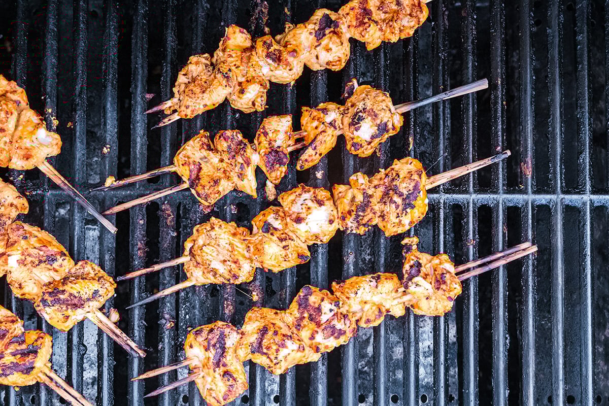 overhead shot of harissa chicken kabobs on grill