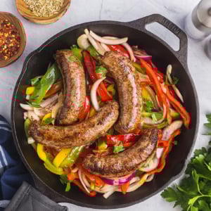 overhead shot of homemade italian sausage in pan with peppers and onions