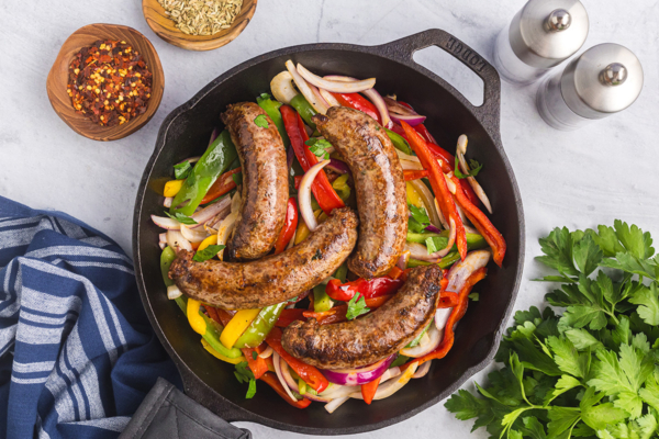 overhead shot of homemade italian sausage in pan with peppers and onions