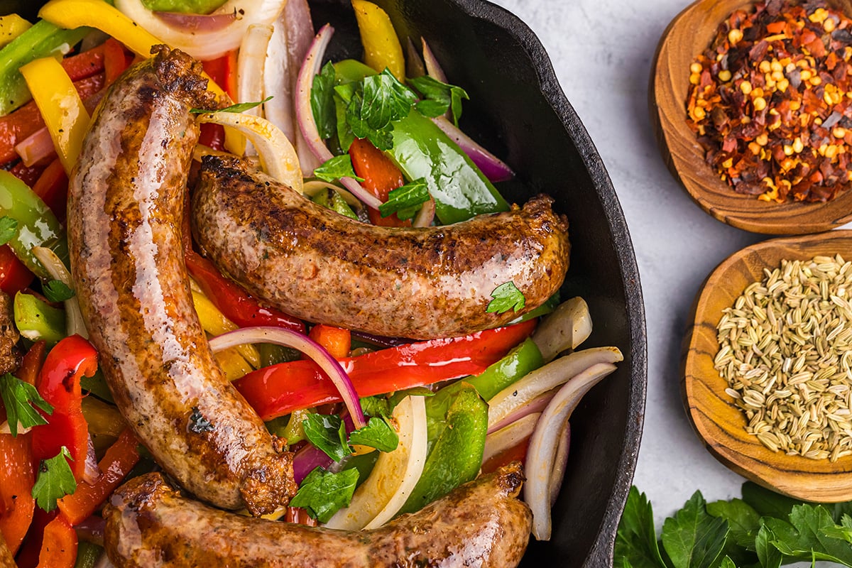 close up overhead shot of homemade italian sausage in pan with peppers and onions
