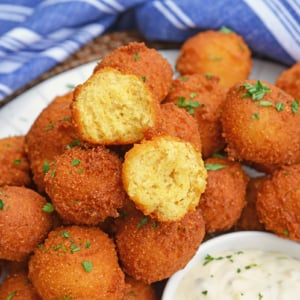angled shot of pile of hush puppies with one cut in half