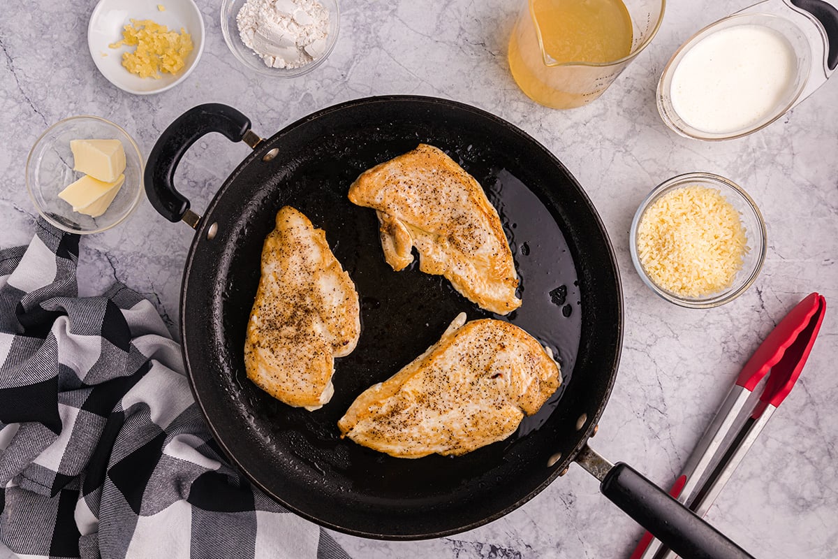 overhead shot of chicken cooking in a skillet