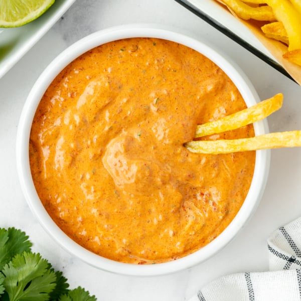two french fries in bowl of chipotle mayo