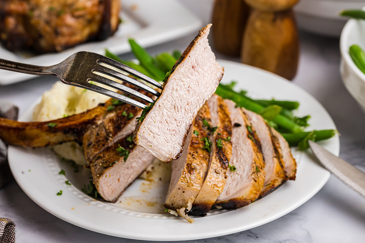 fork holding slice of pork chop
