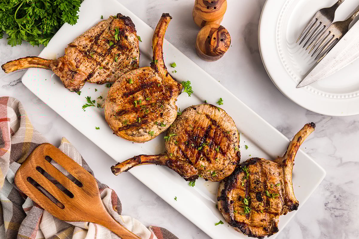 overhead shot of four onion grilled pork chops on platter