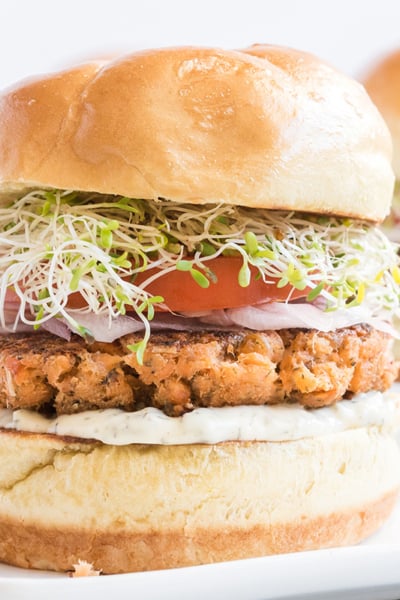 close up shot of salmon burger on plate