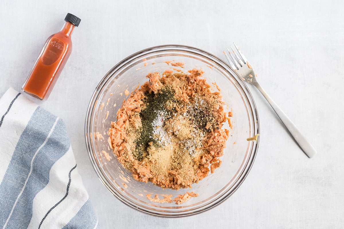 overhead shot of salmon burger meat with seasonings in bowl