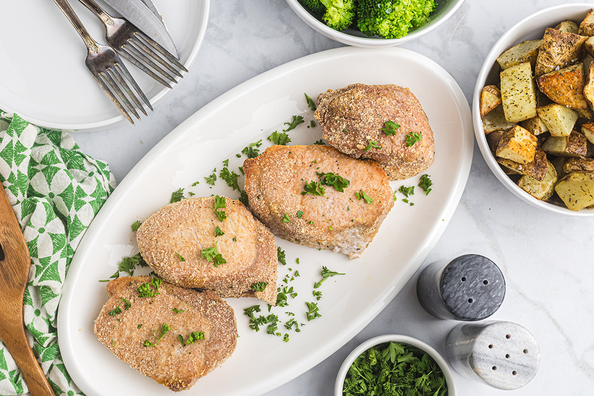 overhead shot of four baked pork chops on platter