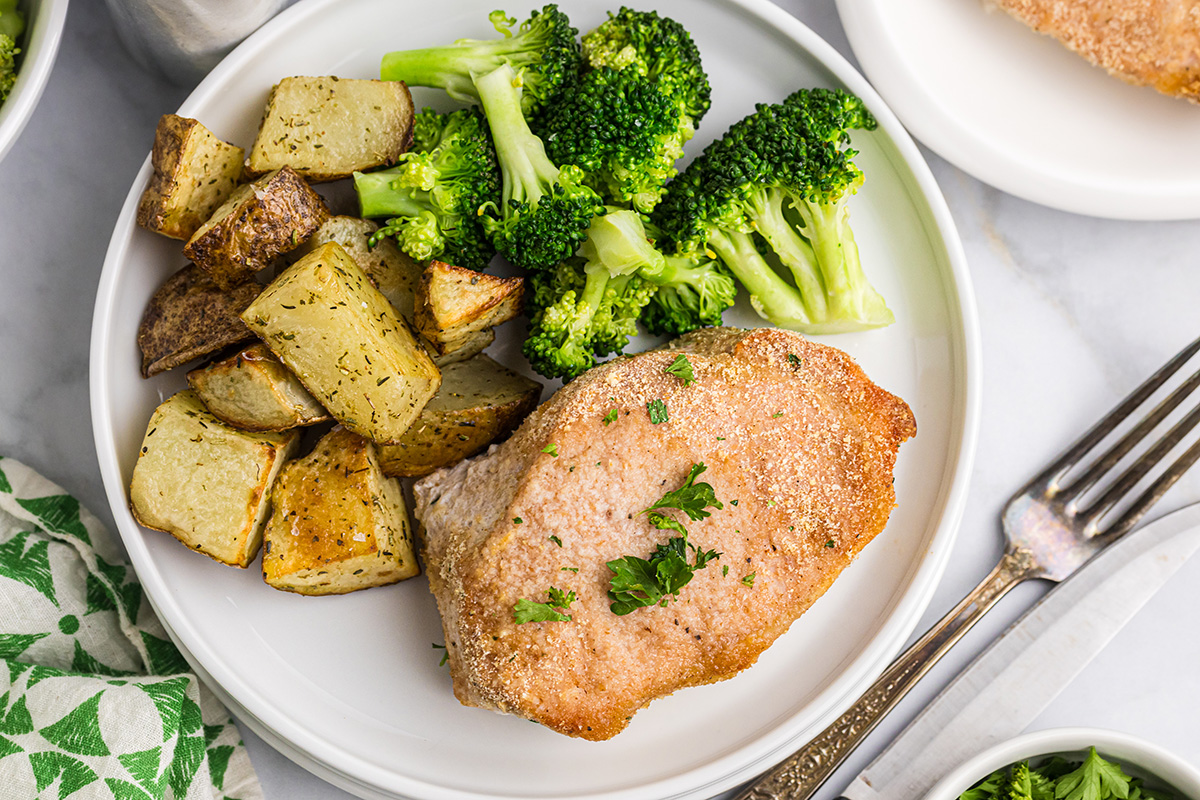 close up overhead shot of plate of shake n bake pork chops, broccoli and potatoes