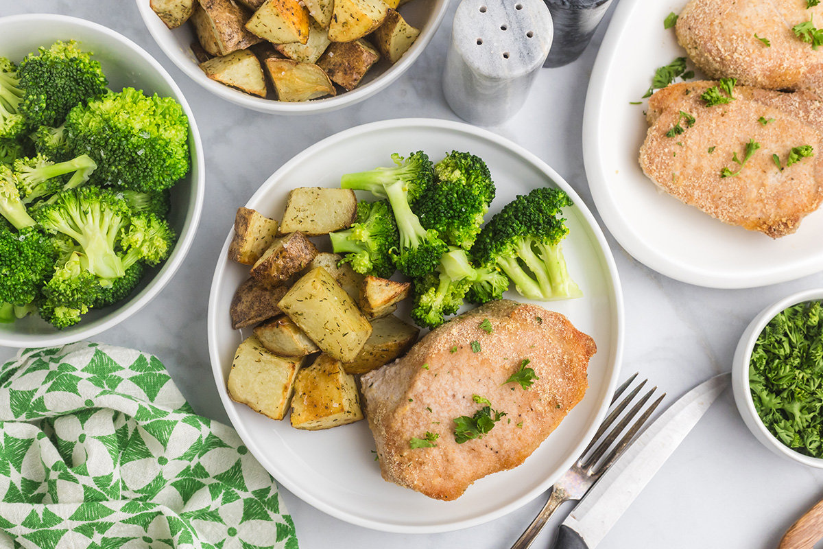overhead shot of plate of shake n bake pork chops, broccoli and potatoes