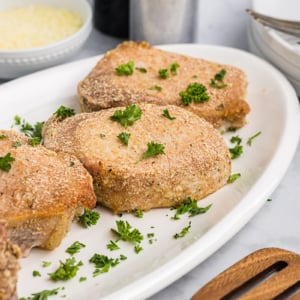 angled shot of four crispy pork chops on a platter