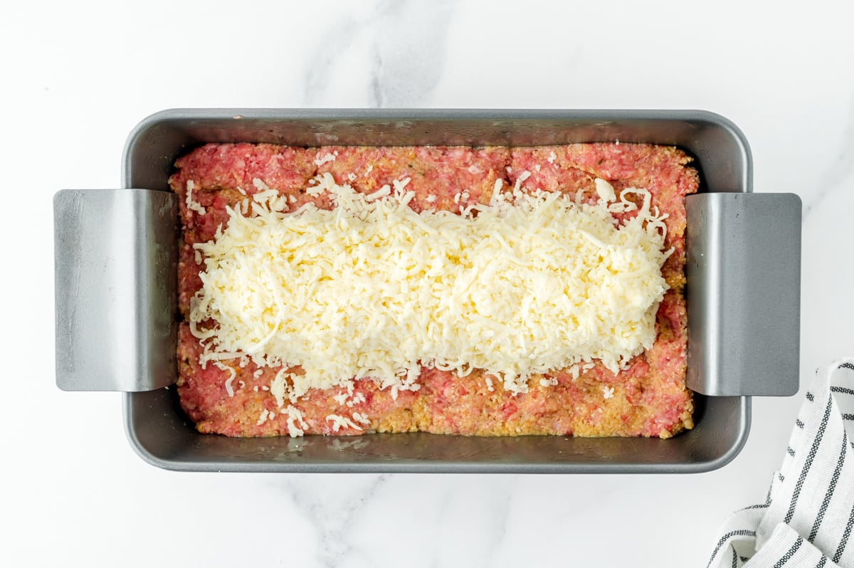 overhead shot cheese added to meat mixture in pan